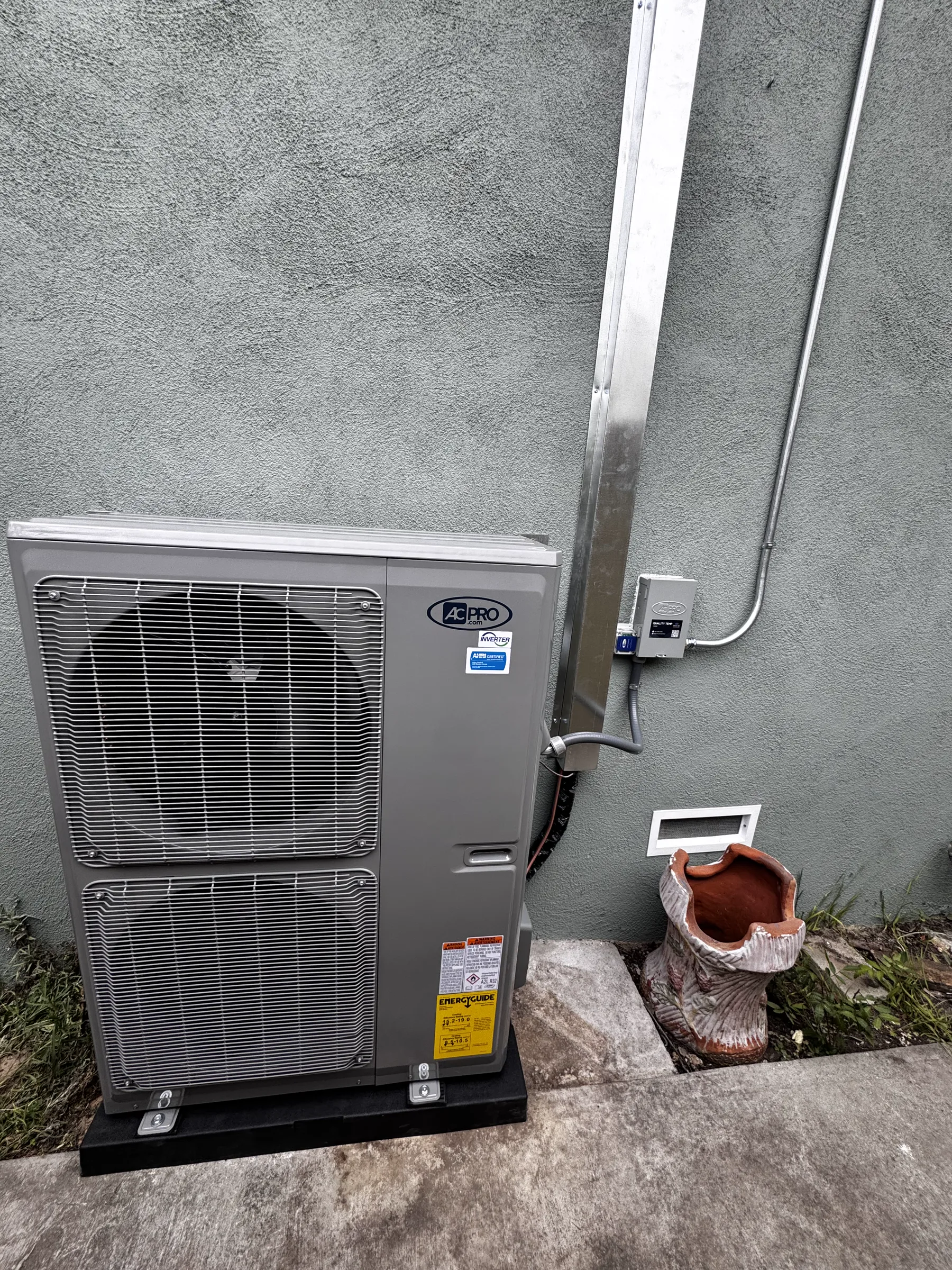 Outdoor HVAC system installed beside a stucco wall